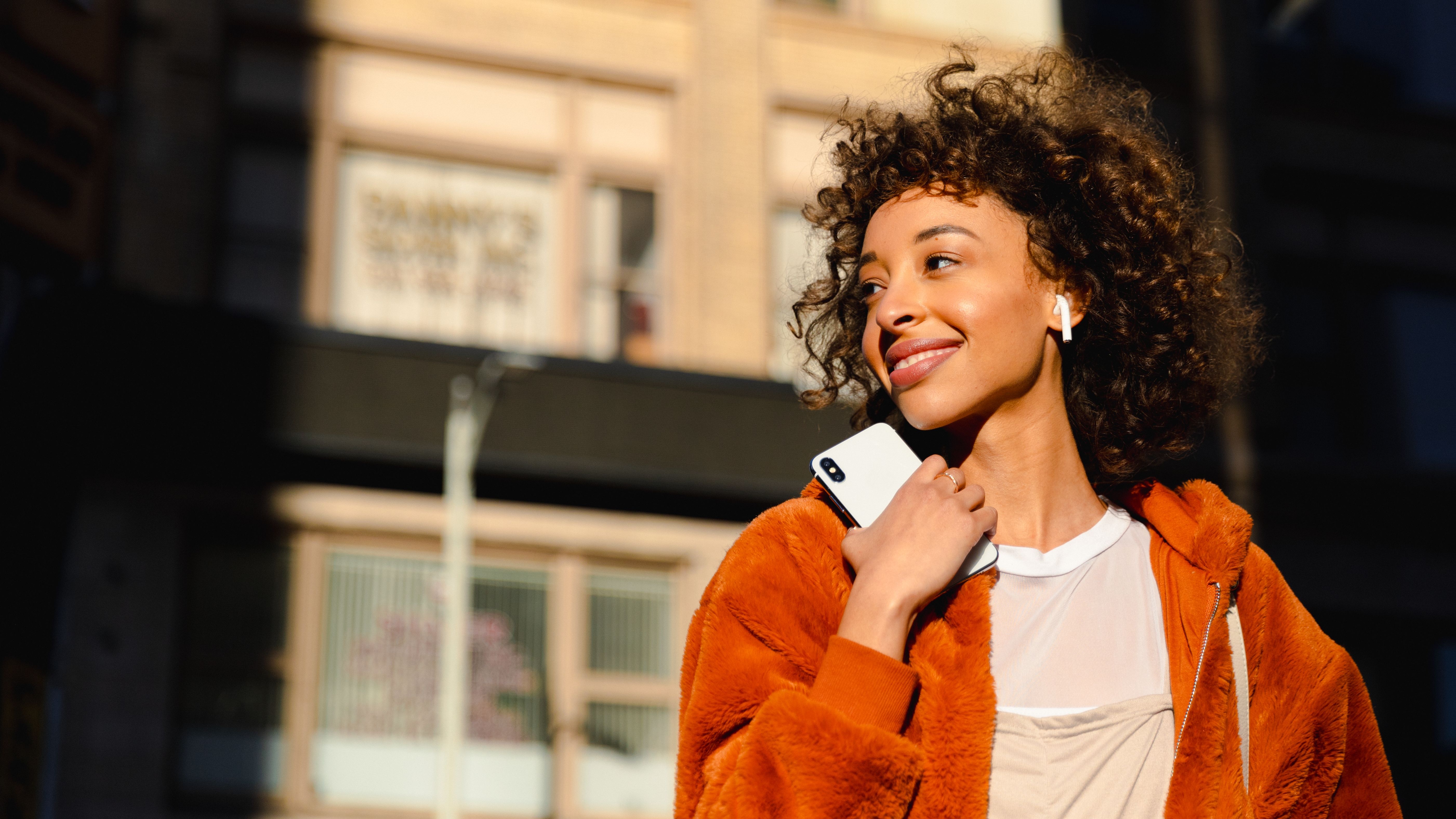 Mulher usando smartphone com PayzuCell - Conectividade móvel integrada